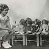 Shirley Temple and dolls for the Dionne Quintuplets, December 1935